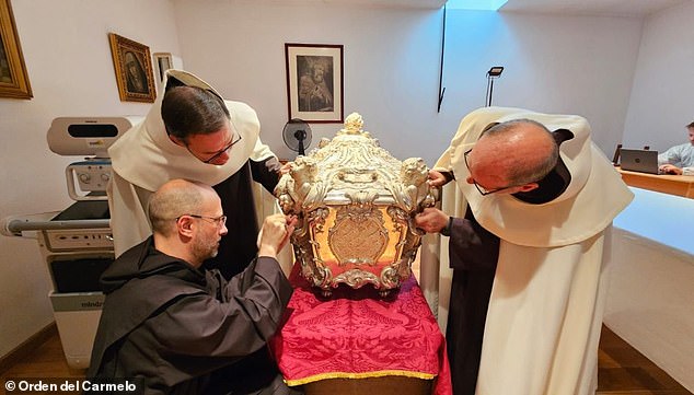 It is expected to take several months before doctors and scientists receive the results of their analyses from a laboratory in Italy. Pictured: The silver coffin covered in marble of St Teresa of Avila