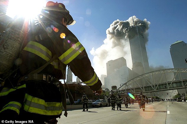 Firefighters walk toward one of the World Trade Center towers before it collapsed