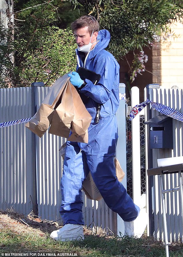 Forensic experts remove bags of evidence from the house