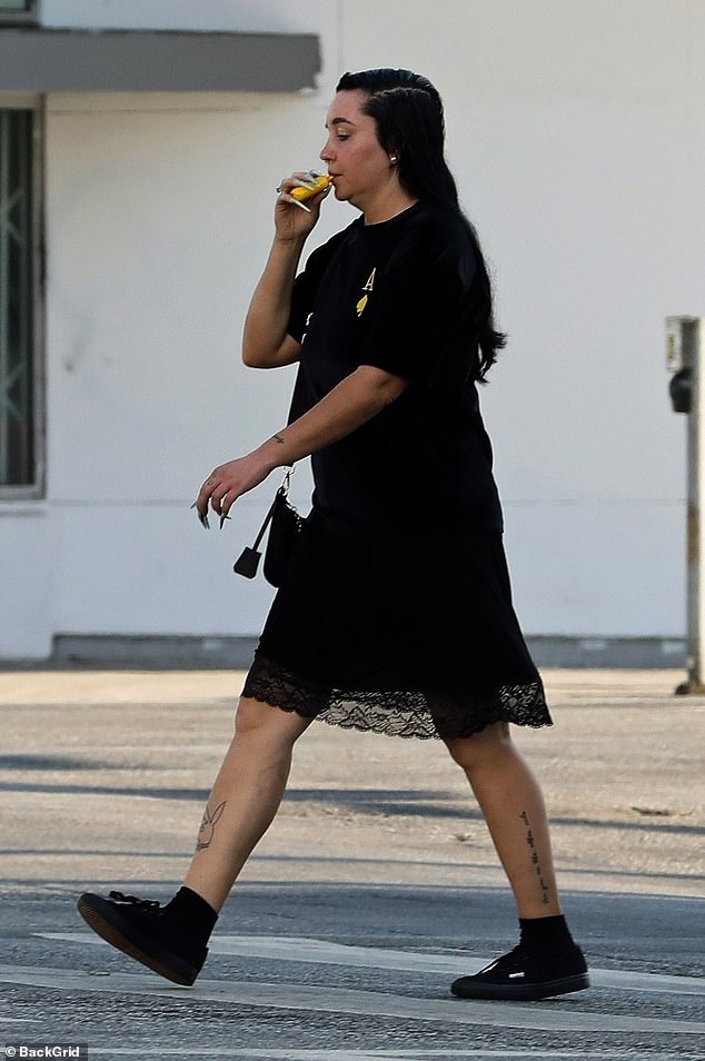 For her walk, she looked effortlessly chic as she layered a T-shirt over a knee-length lace-trimmed slip dress. The Nickelodeon alum rocked all-black sneakers with ankle-high socks.