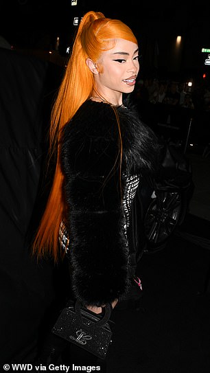 Her bright orange hair was styled half up, half down and she sported a glossy nude lipstick.