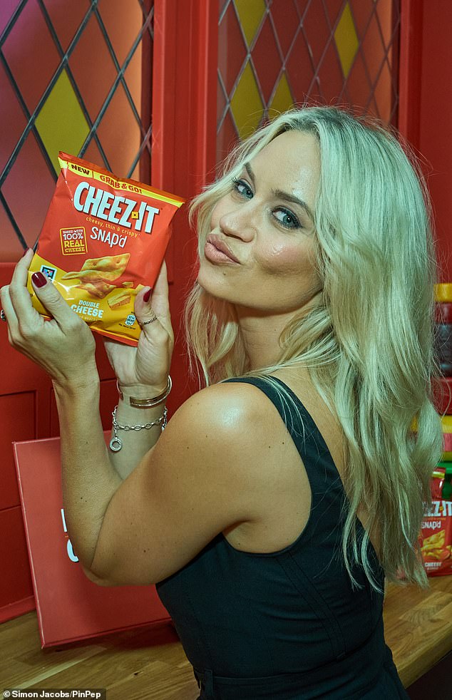 Former Dancing On Ice contestant Kimberly even pouted next to a package as she stood in a vest with her blonde locks falling down her back.