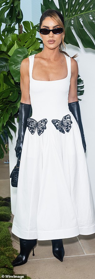 Camila Coelho wore a white round-neck dress with black butterfly details.