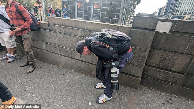 Herald Sun photographer Jake Nowakowski hunches over in pain after being gassed by police