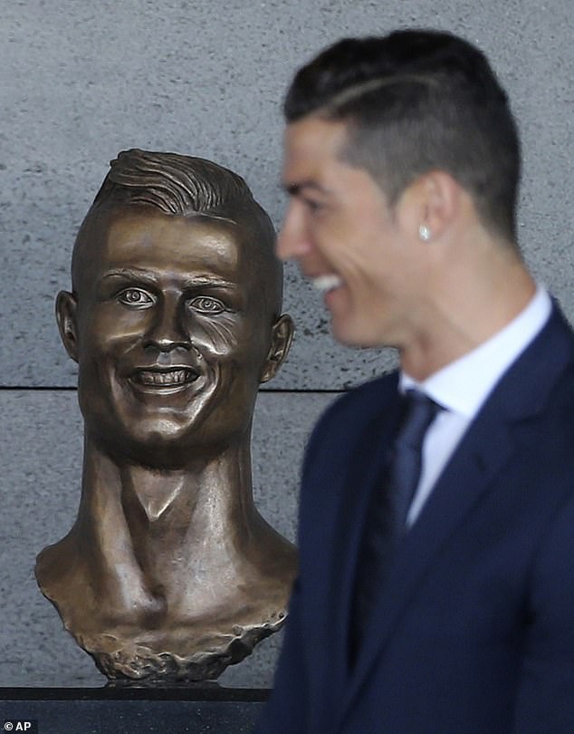 Cristiano Ronaldo stands next to his bust near Madeira airport in 2017