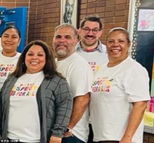 Wicks (middle) appears on the school's website, smiling alongside a group of teachers and administrators.