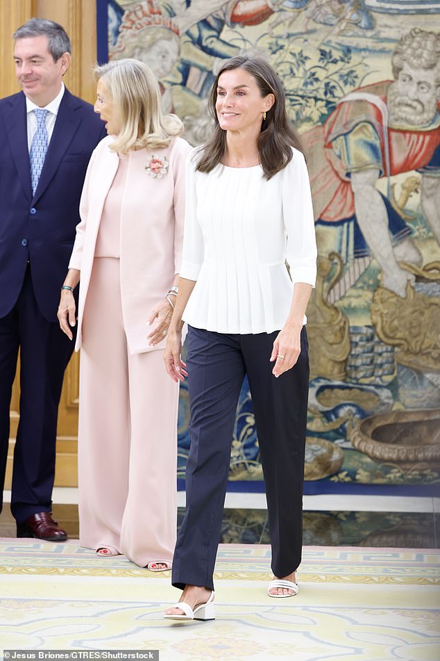 The royal opted for a white pleated blouse paired with dark fitted trousers and white chunky-heeled sandals.