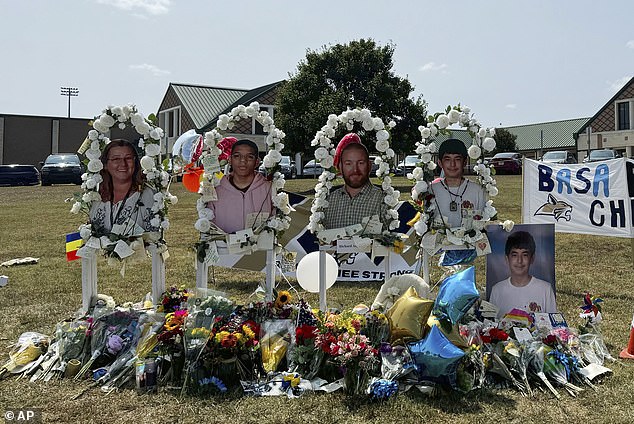 Poster images of the victims are displayed at a memorial outside the high school on Tuesday.