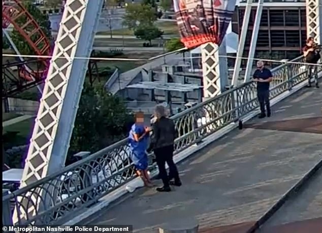 He then leans over the side railing before approaching the woman before heroically lifting her over the railing and hugging her.