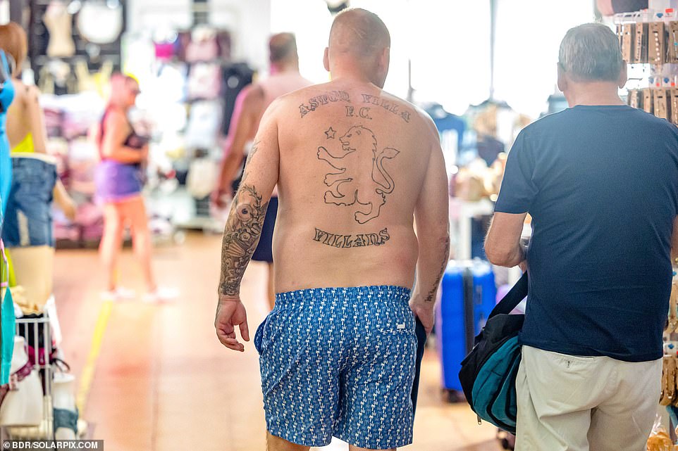 Shirtless Brits are a regular fixture in the region during the summer. Here one is seen with an Aston Villa FC tattoo on his back.