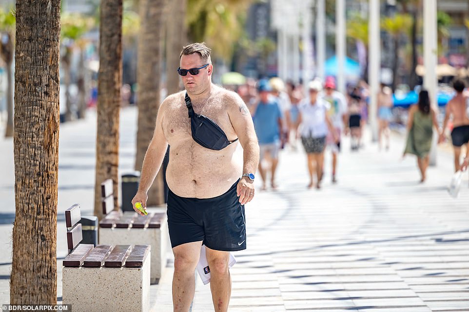 Shirtless Brit enjoys the sunshine in Benidorm, far from the UK's autumn chill