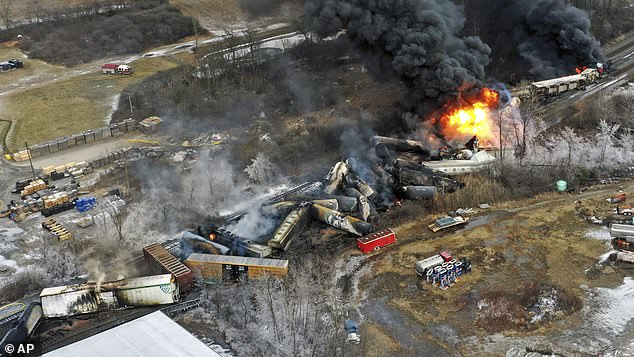 The remains of a Norfolk Southern freight train lie scattered and burning along the tracks, Feb. 4, 2023, the day after it derailed in East Palestine, Ohio.