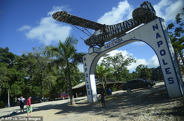 People pose for photographs at the entrance to the Hacienda Nápoles theme park, once drug lord Pablo Escobar's private zoo at his Nápoles ranch.