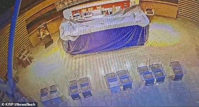 CCTV shows the suspect walking towards a stall before someone else runs in. A security guard stops him in his tracks.