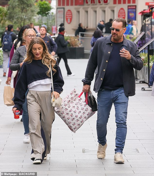 The influencer also wore beige striped pants and black shoes and completed her look with a cream-colored handbag.