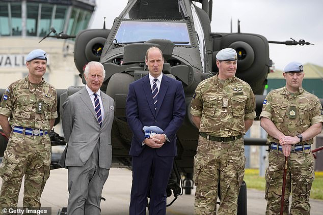 Britain's King Charles III poses with service personnel after officially handing over the role of Colonel-in-Chief of the Army Air Corps to Prince William