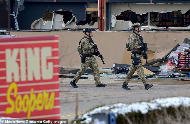 Armed police officers are seen outside broken windows at King Soopers on Table Mesa Drive in Boulder after reports of shots fired on Monday, March 22, 2021