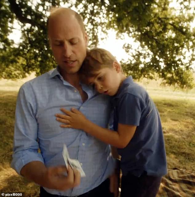 Prince Louis hugs his father, Prince William, as the family plays cards