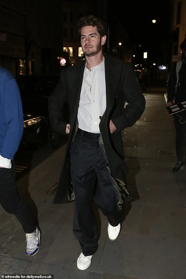 Andrew Garfield wore a loose white shirt and dark pants while completing the whole outfit with a pair of sneakers.