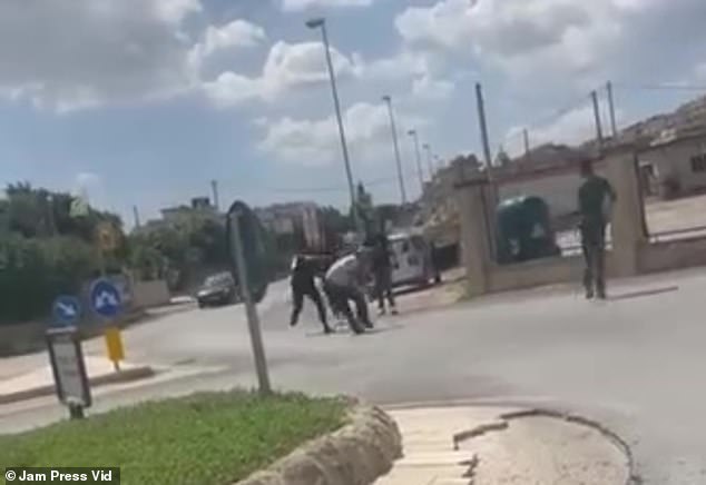 In another video, the occupants of the car are seen chasing away the two gardeners in front of a group of onlookers, who can be heard in the background.