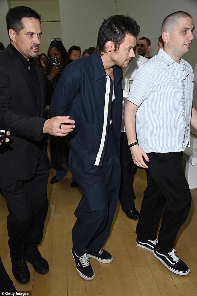 The singer, who co-owns the fashion label with fashion designer Steven Stokey-Daley, paired the navy shirt with a matching pair of tailored trousers.