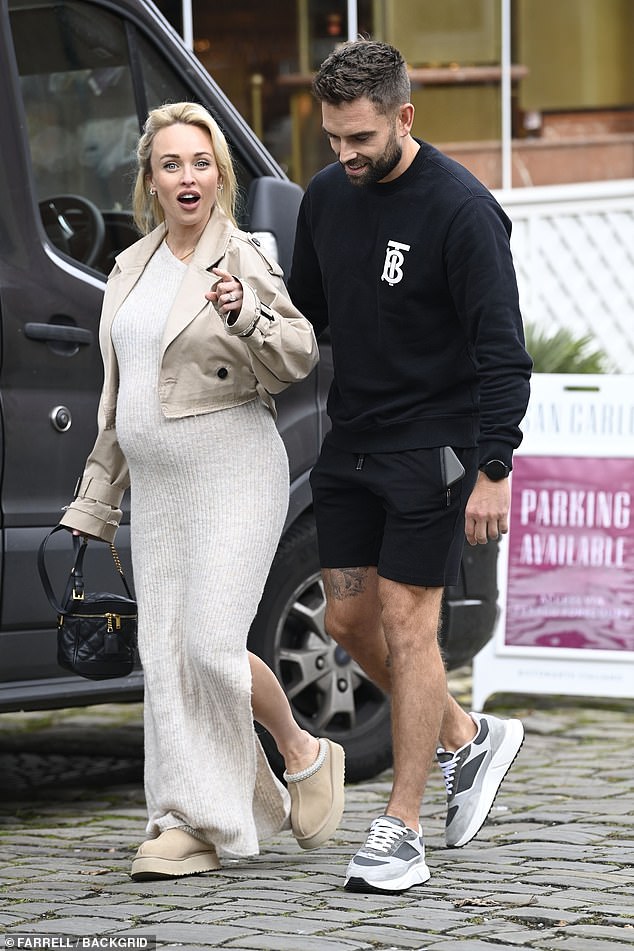 She completed her ensemble with a cropped beige trench coat and accessorized her look with small hoop earrings.