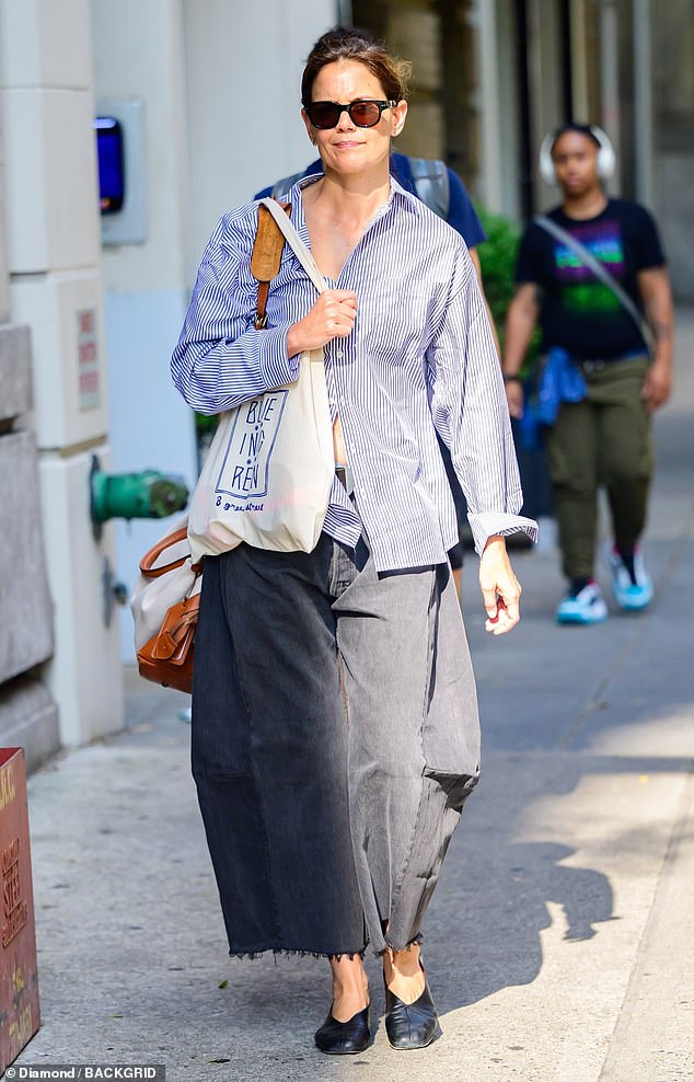 Holmes' long, dark hair was pulled back into a loose bun and her makeup looked natural behind a pair of black-framed sunglasses.