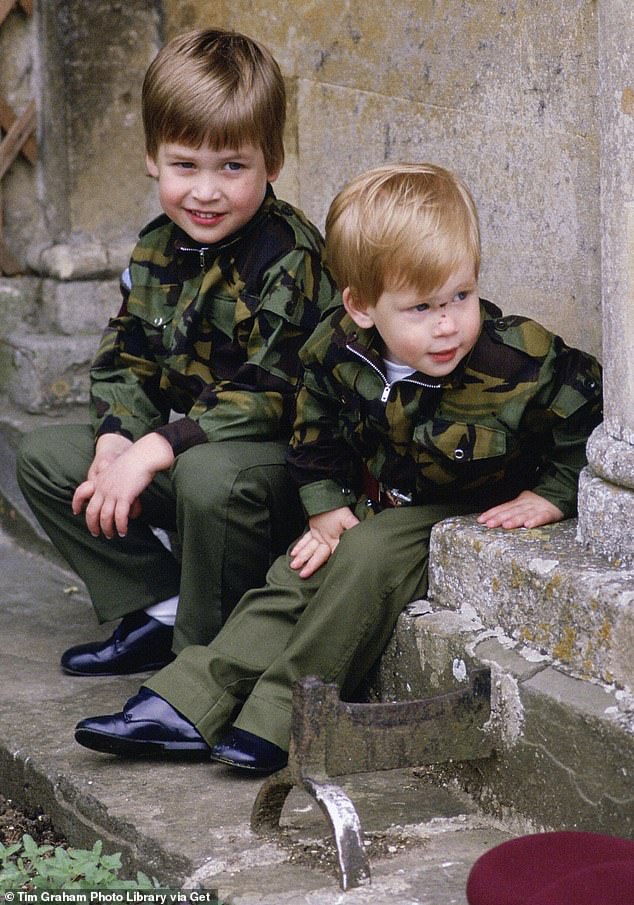 Prince Harry and Prince William sit together on the steps of Highgrove House wearing military uniforms in July 1986.