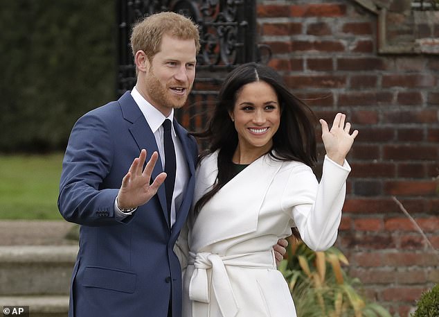 Britain's Prince Harry and his fiancee Meghan Markle pose for photographers during a photocall in the gardens of Kensington Palace in London, Monday, Nov. 27, 2017.