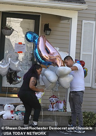 Family and friends gathered to honor the family with an impromptu vigil featuring balloons and stuffed animals outside their home on Knapp Avenue.