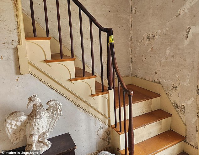 A grand staircase is one of the house's biggest draws and features beautiful original wood, but still needs restoration to some extent.