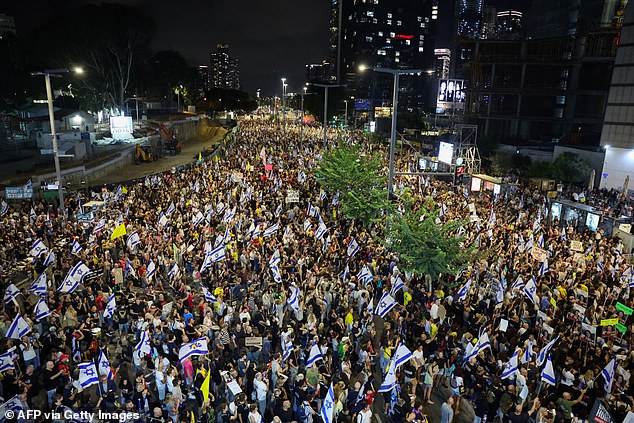 Protesters hold up flags and signs during an anti-government demonstration demanding action to free Israelis held hostage by Palestinian militants in Gaza since October.