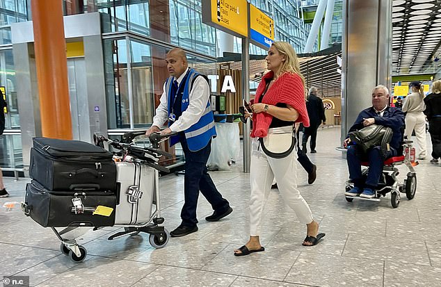 She put on an effortless display of style for the flight, wearing white trousers and a low-cut black top, with a red sweater draped over her shoulders.