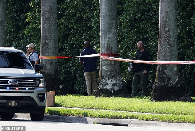 Police search the tree line and brush outside Trump International Golf Club, where the gunman was hiding and where he left his belongings when he fled the scene.