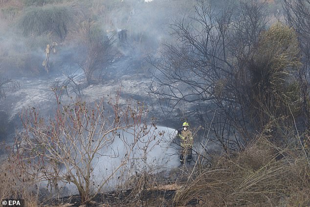 A firefighter extinguishes a fire that broke out after the Houthis claimed to have launched a hypersonic missile