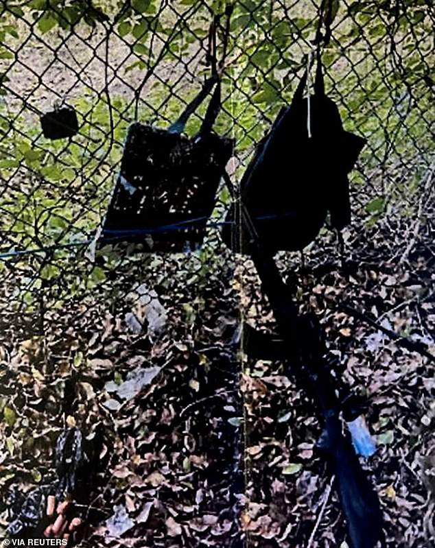 The gunman had a scoped AK-style rifle, a GoPro camera and two backpacks hanging from a fence (pictured)