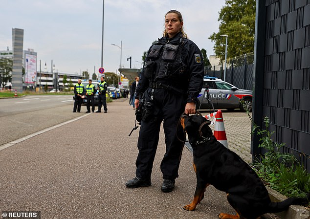 A German policeman stands guard with a dog at the border with France on Monday