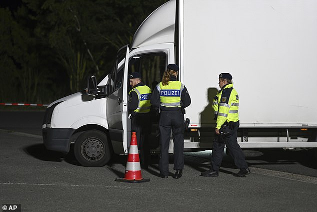 Police officers check a van at the Bunderneuland border crossing early Monday morning.