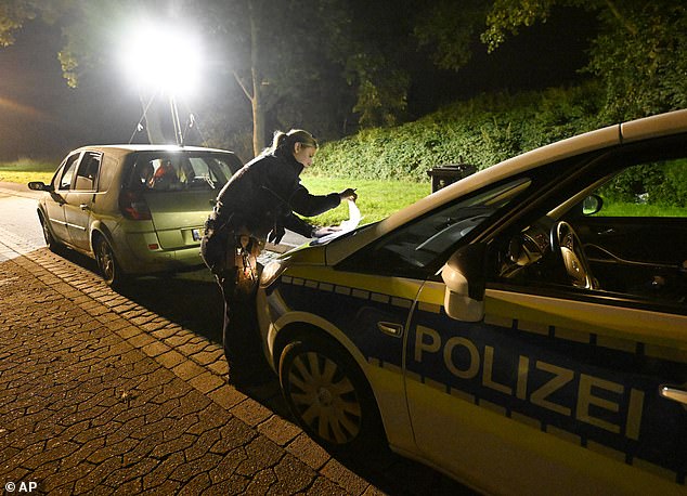 A police officer checks vehicles near the Belgian border in Aachen on Monday.