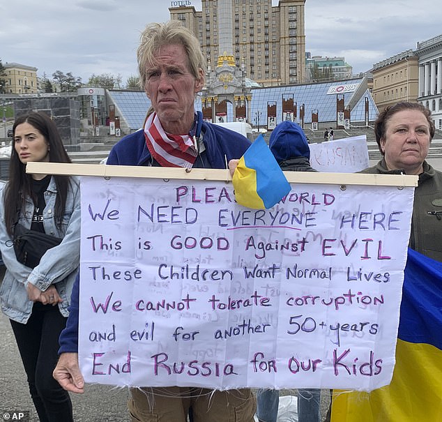 Ryan Wesley Routh holds a banner during a demonstration in central kyiv, Ukraine, Saturday, April 30, 2022.