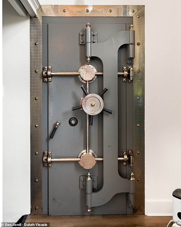 A metal vault door opens to reveal an emerald-painted room with gold safe deposit boxes.