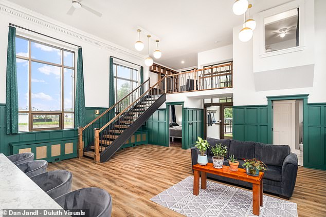 The main space of the house has emerald walls, hardwood floors, and a marble countertop.