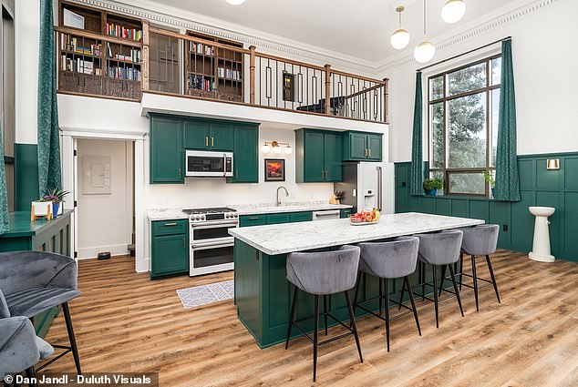 The house has two wooden balcony areas that overlook the floor below.