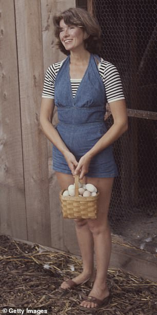 Stewart carries a basket of eggs from a chicken coop on the grounds of his home, Westport, Connecticut, August 1976.