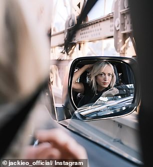 The radio star poses for the rearview mirror on the Brooklyn Bridge