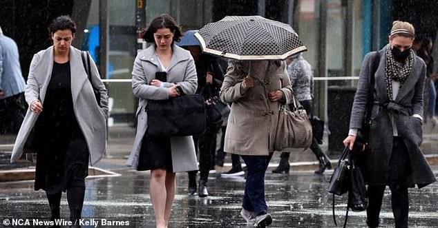 There is a high chance of rain this week in Hobart, combined with very cold temperatures (file photo of people walking in the rain)