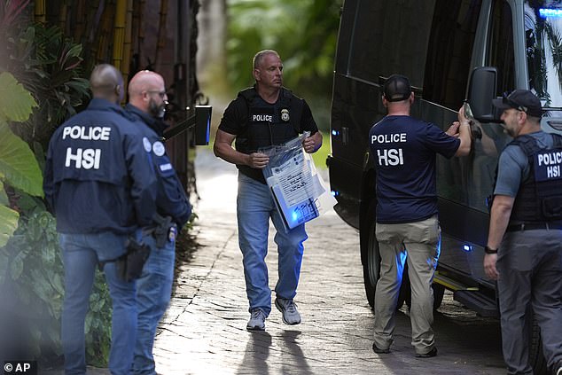 Monday night's indictment comes less than six months after the music mogul's homes in Los Angeles and Miami were raided by federal authorities on March 25. Officials pictured in Miami Beach