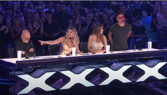 Simon Cowell (right) had joined in the standing ovation for the company's performance, but Mandel (left) was unmoved as the crowd booed his scathing comments.