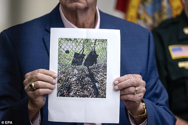 West Palm Beach Sheriff Ric Bradshaw holds a picture of Routh's backpack, purse, GoPro and AK-47-style rifle that were left outside Trump International Golf Club on Sunday when he fled the scene when Secret Service opened fire.