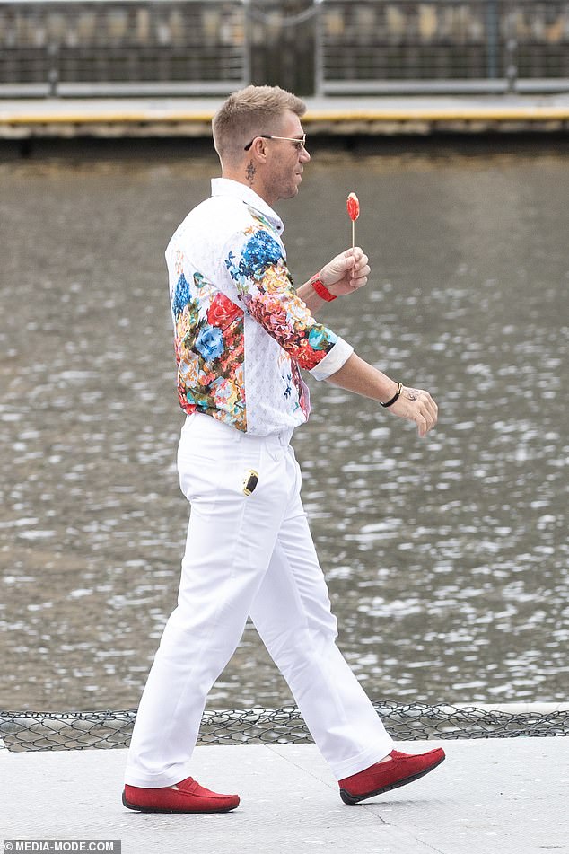 The semi-retired athlete looked every bit the villain from an action movie as he sported fake tattoos on his neck and hands while brandishing the gold prop gun.